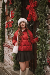 a lady in a red down coat and a black skirt